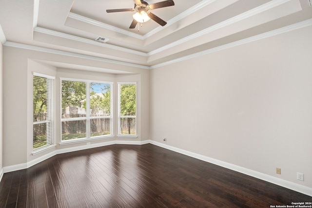 empty room featuring hardwood / wood-style flooring, a raised ceiling, and ornamental molding