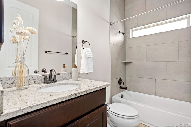 full bathroom with vanity, tiled shower / bath combo, and toilet