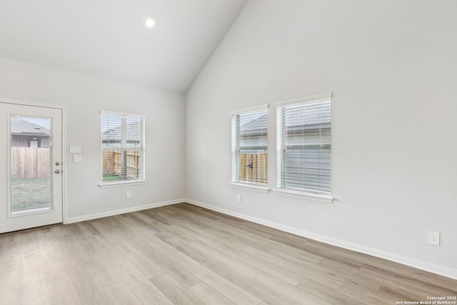 spare room featuring light hardwood / wood-style flooring and vaulted ceiling