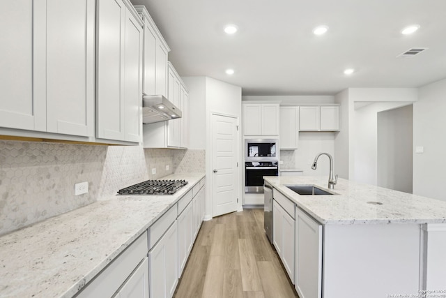 kitchen featuring appliances with stainless steel finishes, tasteful backsplash, white cabinetry, and sink