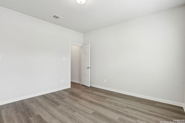 unfurnished room with hardwood / wood-style flooring