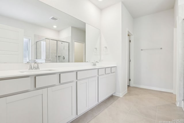 bathroom featuring a shower with shower door, tile patterned floors, and vanity