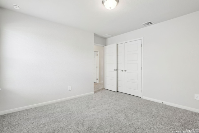 unfurnished bedroom featuring light colored carpet and a closet