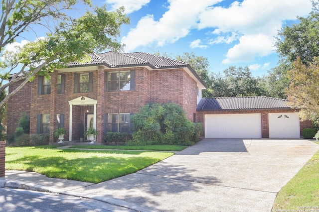 view of front of property featuring a garage, driveway, a front yard, and a tile roof