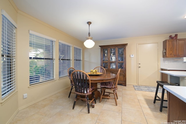 tiled dining space featuring crown molding