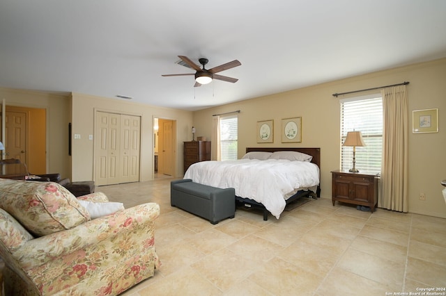 bedroom with light tile patterned floors, ceiling fan, and a closet