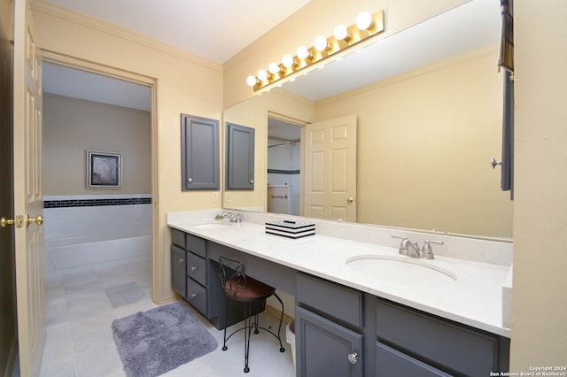 bathroom with ornamental molding, vanity, a tub, and tile patterned floors