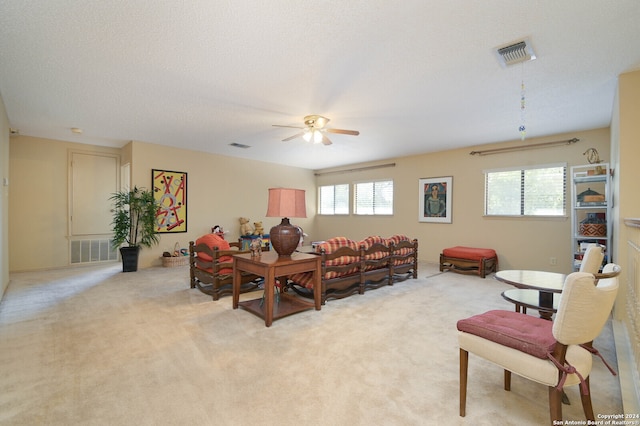 carpeted living room with ceiling fan and a textured ceiling