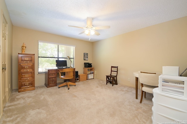 carpeted home office with a textured ceiling and ceiling fan