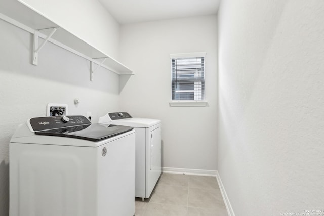 washroom featuring washing machine and dryer and light tile patterned floors