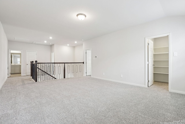 carpeted spare room featuring vaulted ceiling