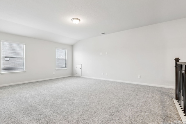 unfurnished living room featuring vaulted ceiling and light carpet