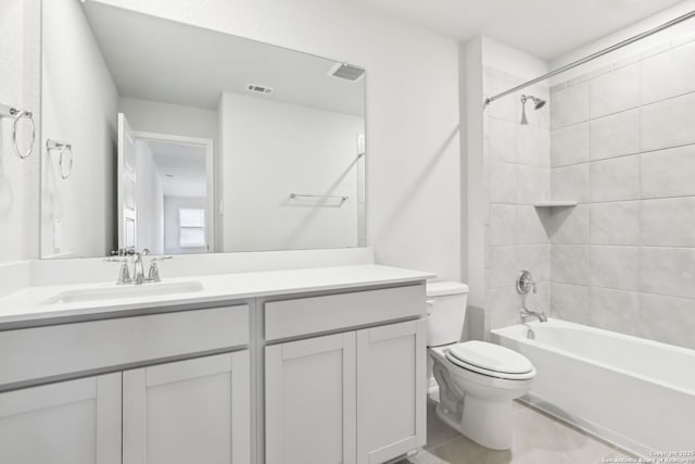 full bathroom featuring toilet, tile patterned flooring, tiled shower / bath, and vanity