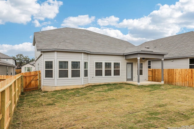 rear view of property with ceiling fan, a patio, and a lawn