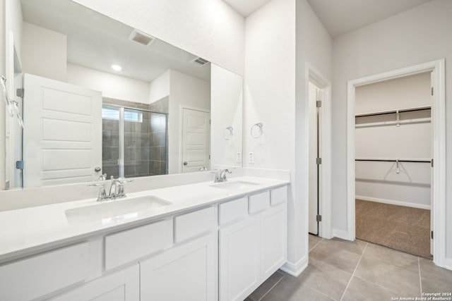 bathroom with tile patterned floors, walk in shower, and vanity