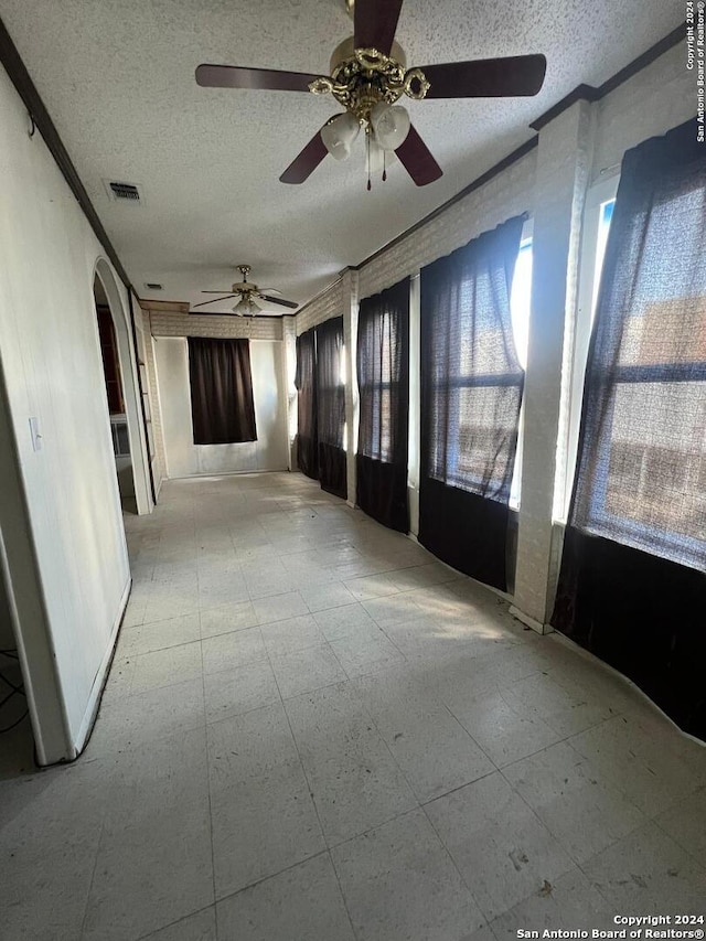 interior space featuring crown molding and a textured ceiling