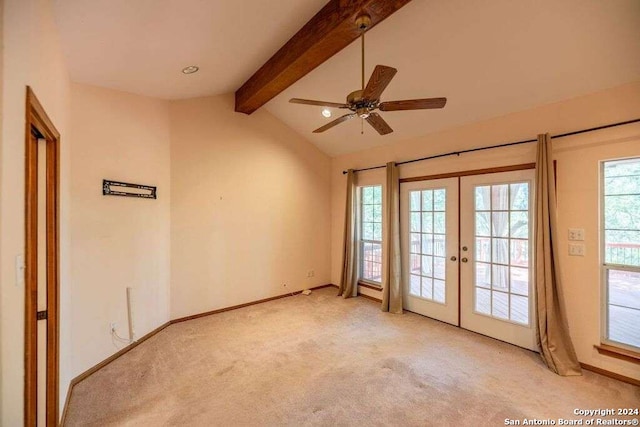 carpeted spare room featuring french doors, a healthy amount of sunlight, ceiling fan, and vaulted ceiling with beams