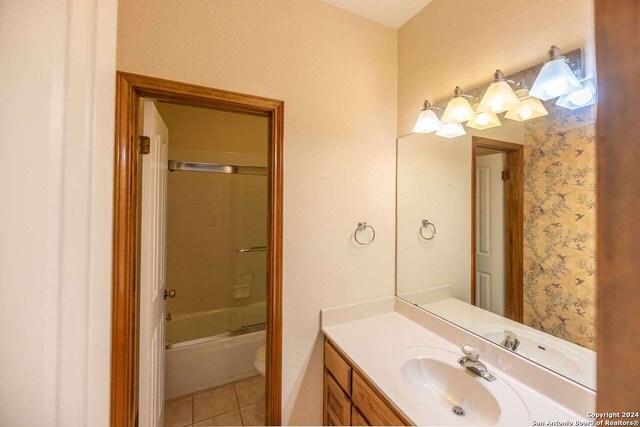 full bathroom featuring combined bath / shower with glass door, vanity, toilet, and tile patterned flooring