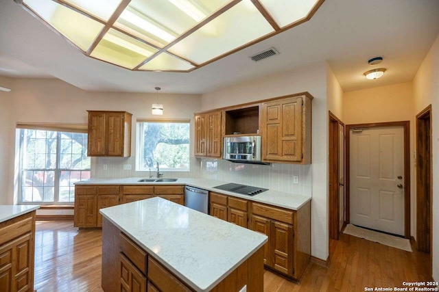 kitchen featuring a center island, stainless steel appliances, sink, and light hardwood / wood-style floors