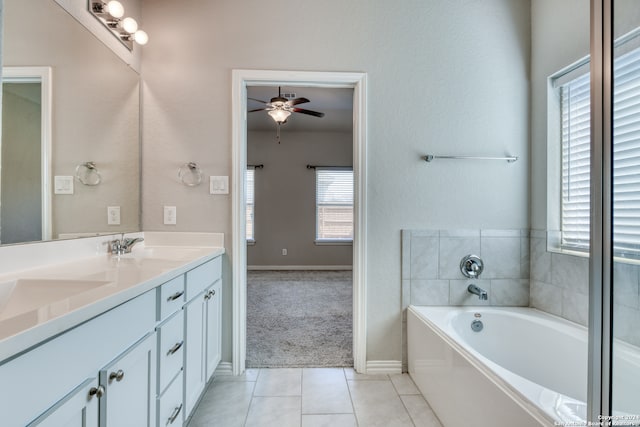 bathroom featuring vanity, a tub, tile patterned floors, and a wealth of natural light