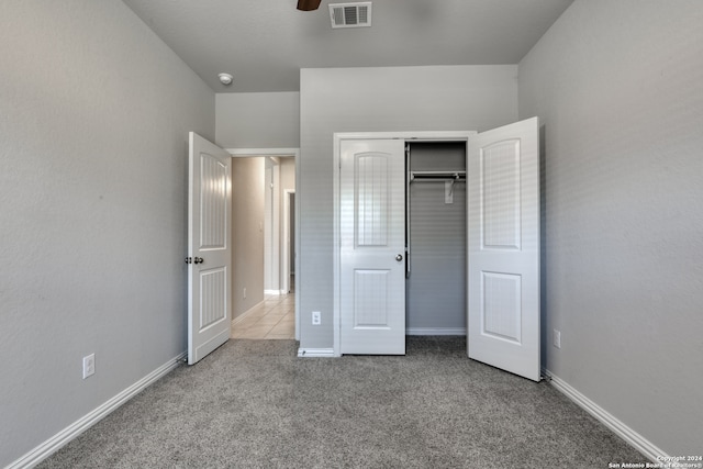 unfurnished bedroom featuring ceiling fan, light carpet, and a closet