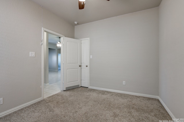 spare room with ceiling fan and light carpet