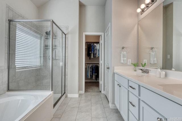 bathroom featuring shower with separate bathtub, vanity, and tile patterned floors