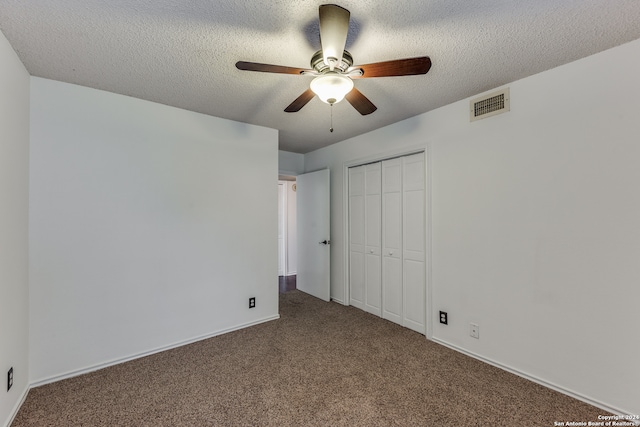 unfurnished bedroom with a textured ceiling, ceiling fan, a closet, and carpet floors