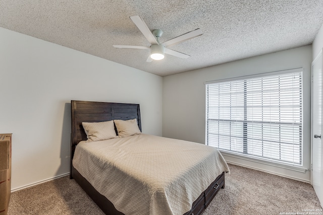 carpeted bedroom featuring multiple windows, ceiling fan, and a textured ceiling