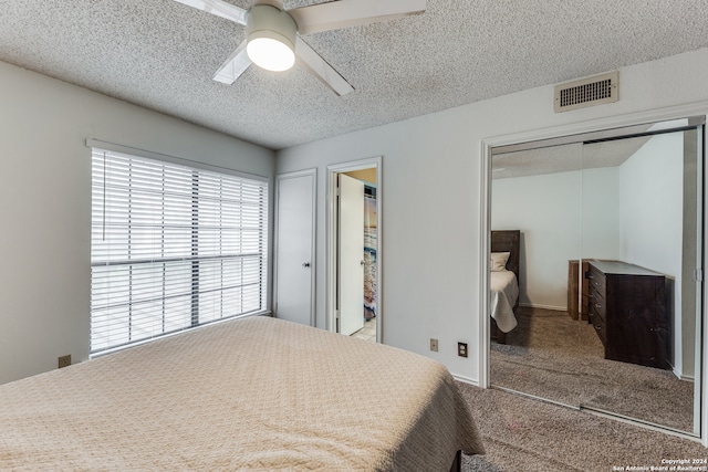 carpeted bedroom with ceiling fan and a textured ceiling