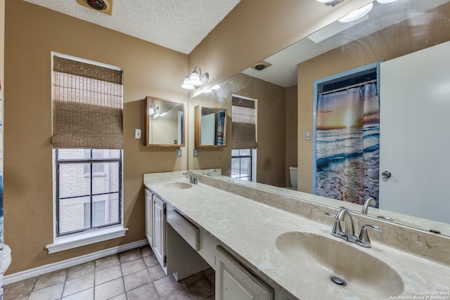 bathroom featuring tile patterned flooring, toilet, plenty of natural light, and vanity