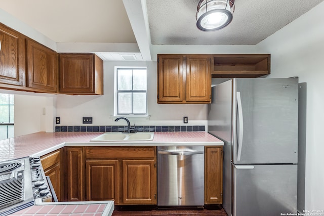 kitchen featuring appliances with stainless steel finishes, a textured ceiling, and sink