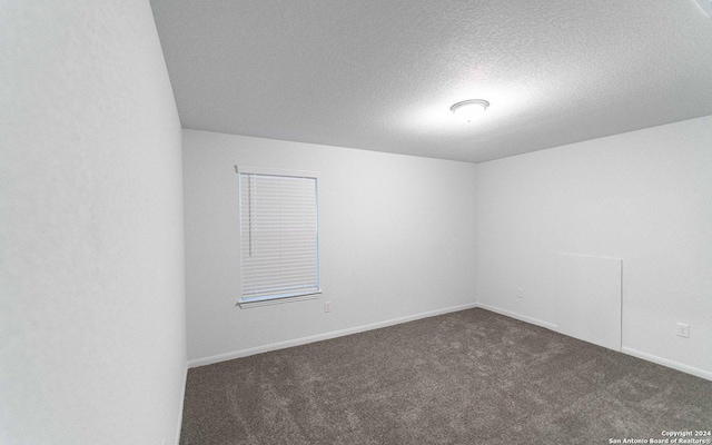413 Tims Way, Seguin, TX 78155 - spare room featuring dark carpet, a textured ceiling, and baseboards