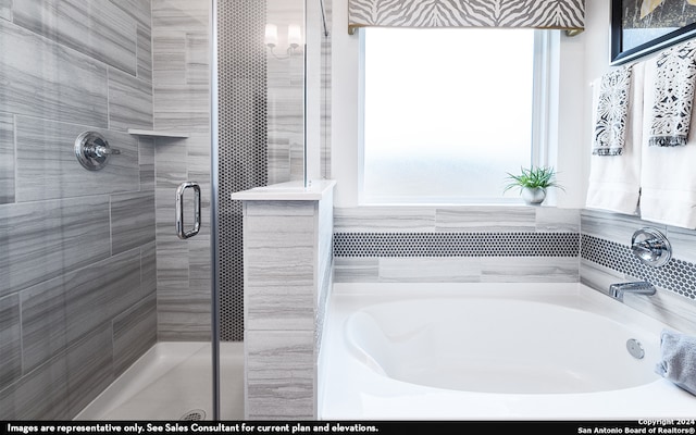 bathroom featuring shower with separate bathtub