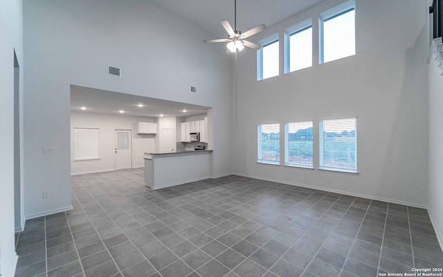 413 Tims Way, Seguin, TX 78155 - unfurnished living room with high vaulted ceiling, ceiling fan, baseboards, dark tile patterned flooring, and recessed lighting