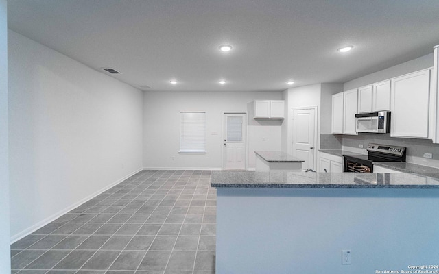 413 Tims Way, Seguin, TX 78155 - kitchen featuring appliances with stainless steel finishes, recessed lighting, dark stone countertops, white cabinets, and baseboards