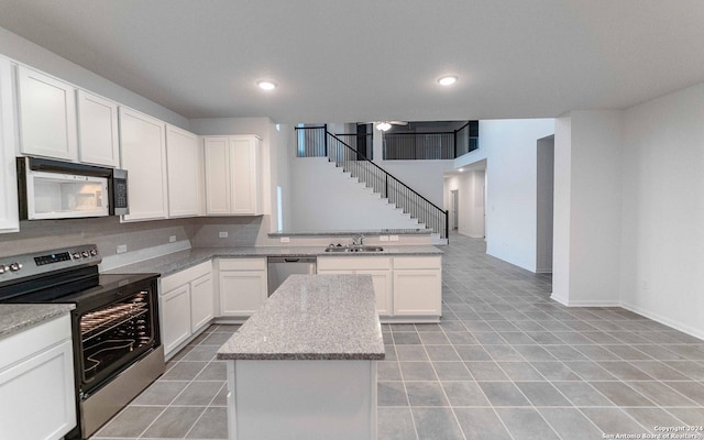 413 Tims Way, Seguin, TX 78155 - kitchen with stainless steel appliances, a center island, white cabinetry, and recessed lighting