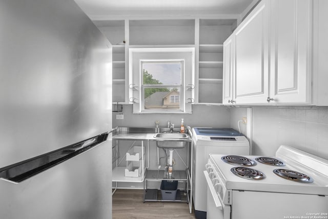 kitchen with hardwood / wood-style floors, white electric range, stainless steel fridge, sink, and white cabinets