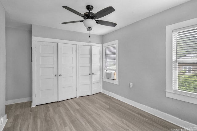 unfurnished bedroom with light hardwood / wood-style flooring, cooling unit, and ceiling fan