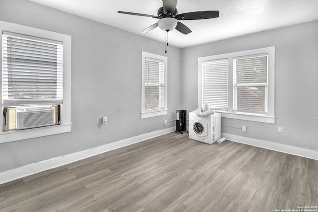 empty room featuring cooling unit, ceiling fan, and light hardwood / wood-style flooring