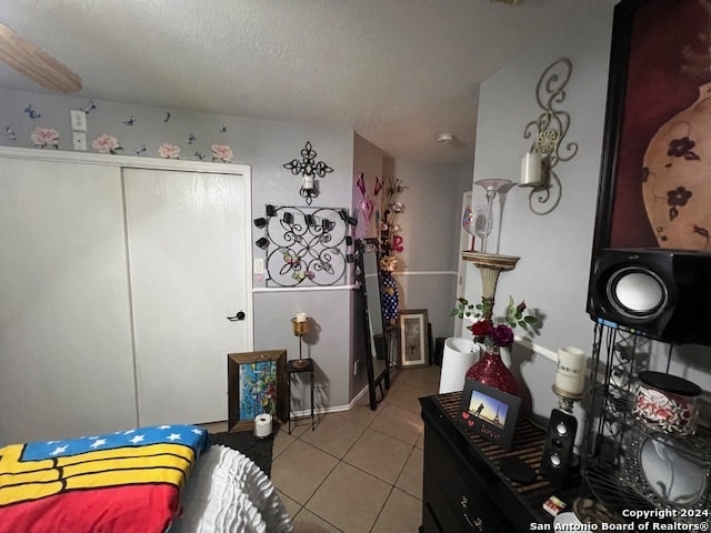 bedroom featuring light tile patterned floors and a textured ceiling