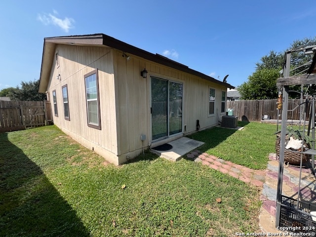 back of property featuring cooling unit, a yard, and a patio