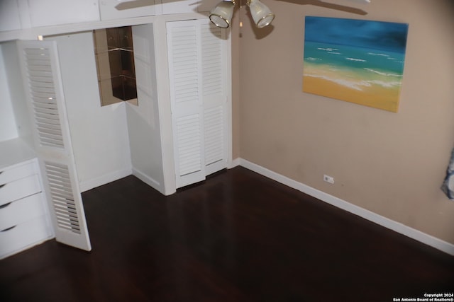 unfurnished bedroom featuring dark hardwood / wood-style flooring and a closet