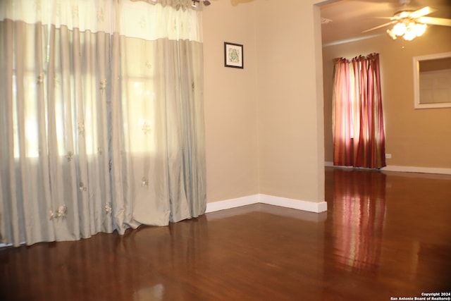 empty room with ceiling fan and dark hardwood / wood-style floors