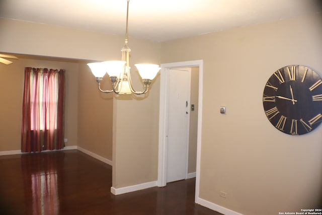 unfurnished room with an inviting chandelier and dark hardwood / wood-style floors