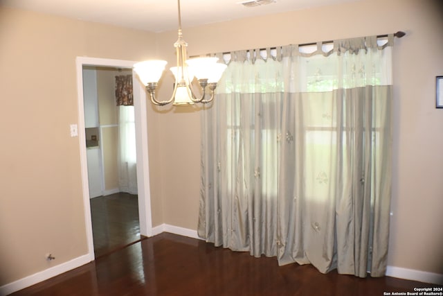 interior space featuring dark wood-type flooring and a notable chandelier