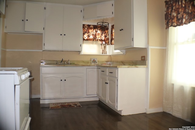 kitchen with white stove, white cabinetry, sink, and dark hardwood / wood-style floors