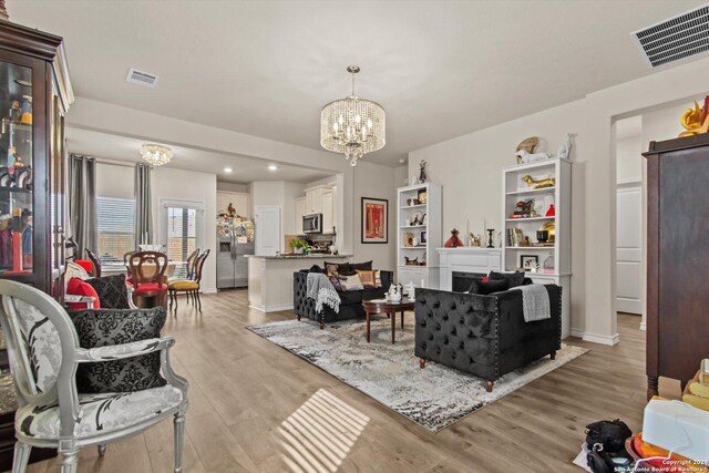 living room with a chandelier and light wood-type flooring