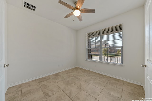 tiled spare room featuring ceiling fan