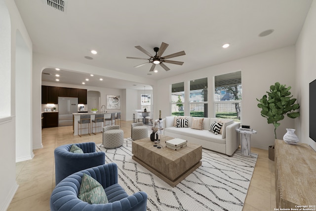 living room with ceiling fan, sink, and light tile patterned floors